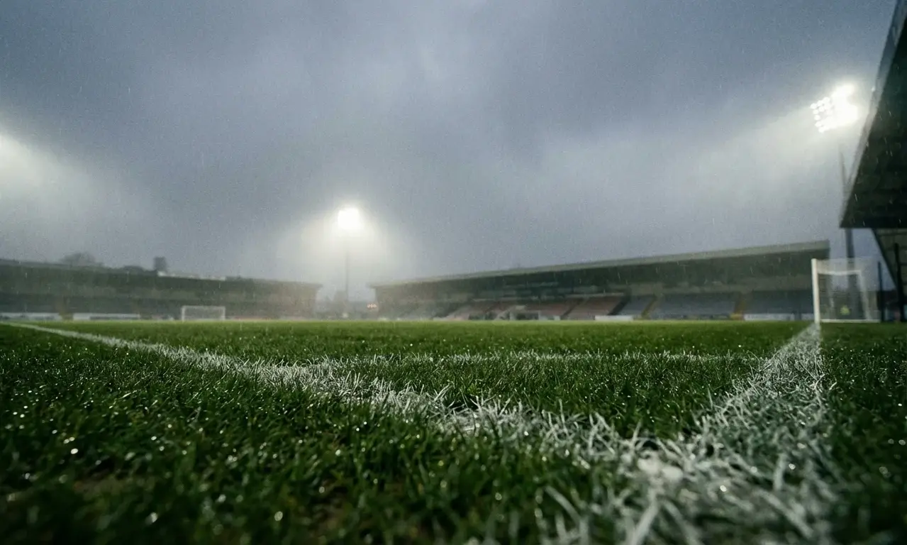 Partido de fútbol bajo la lluvia para análisis de apuestas y condiciones del juego